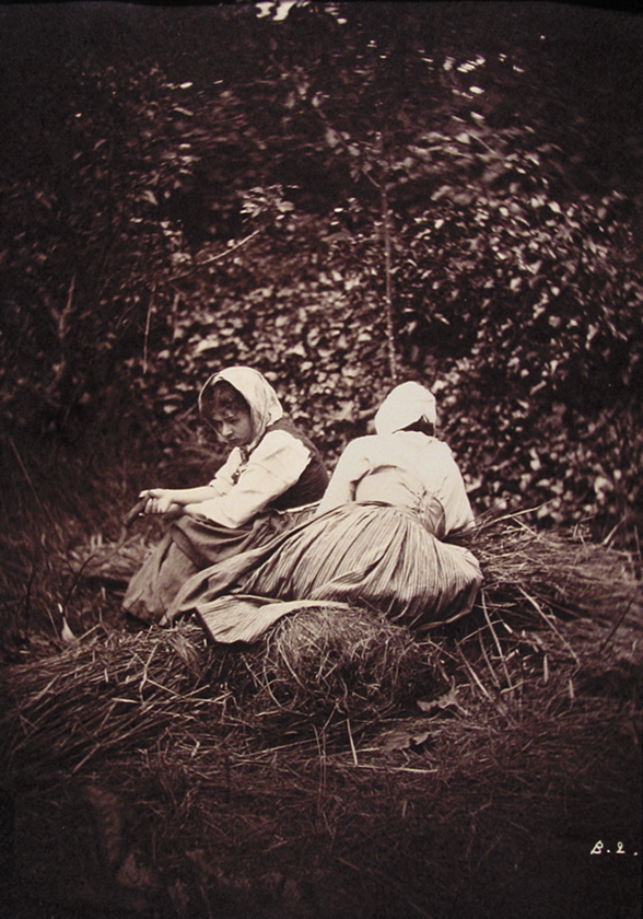 Two women resting on bundles