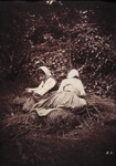 Two women resting on bundles